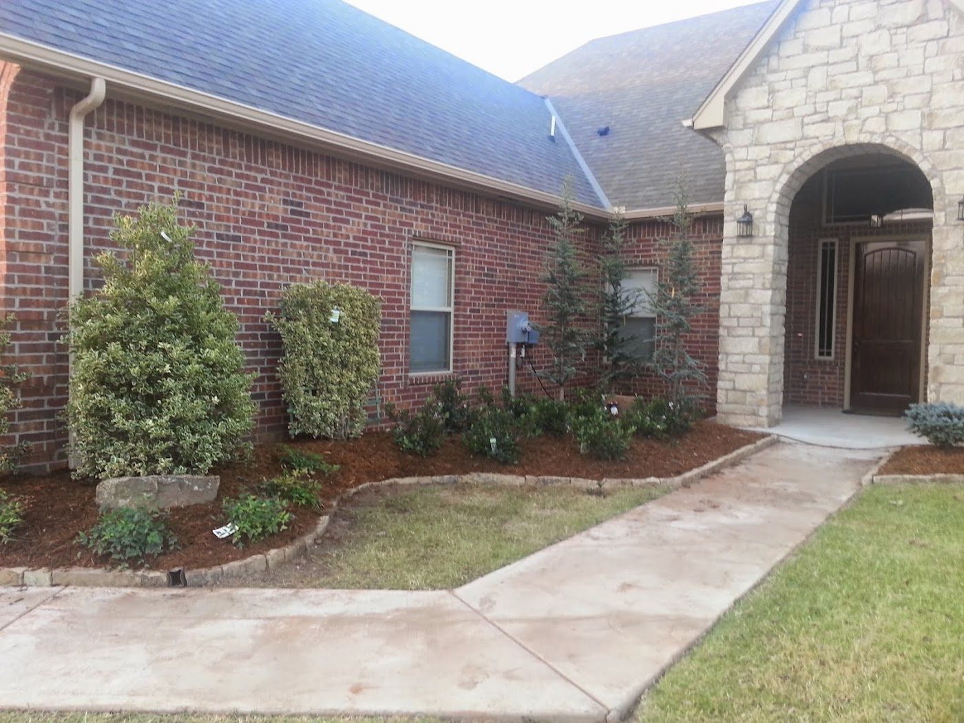 Fresh landscaping along the front walk of a brick home