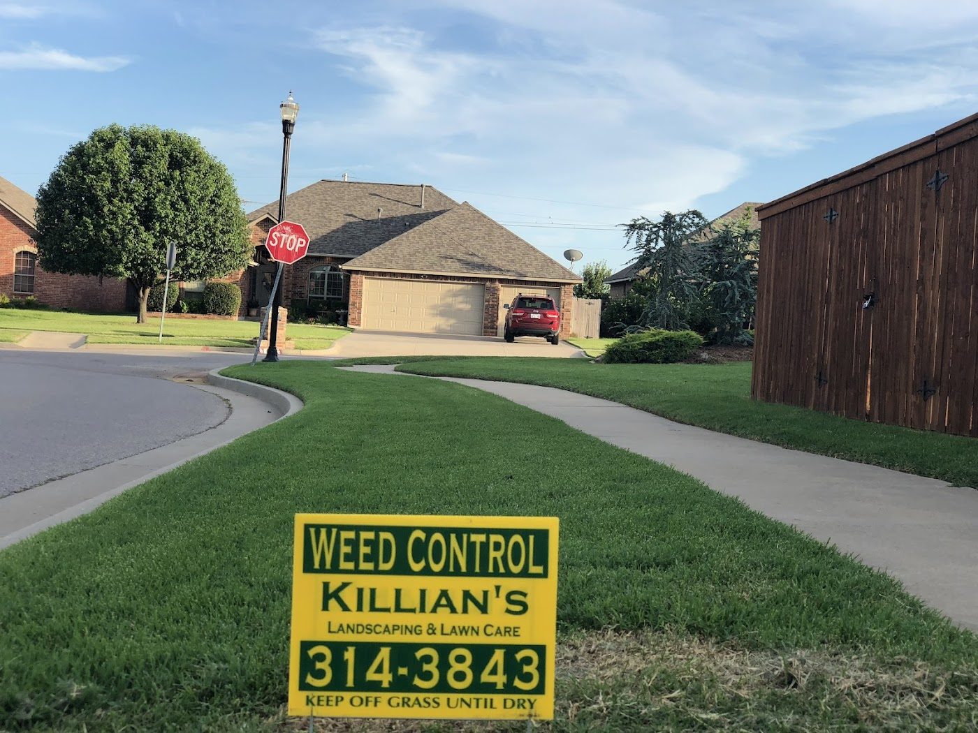 A Killian's weed control sign on a freshly treated, deep-green Moore lawn